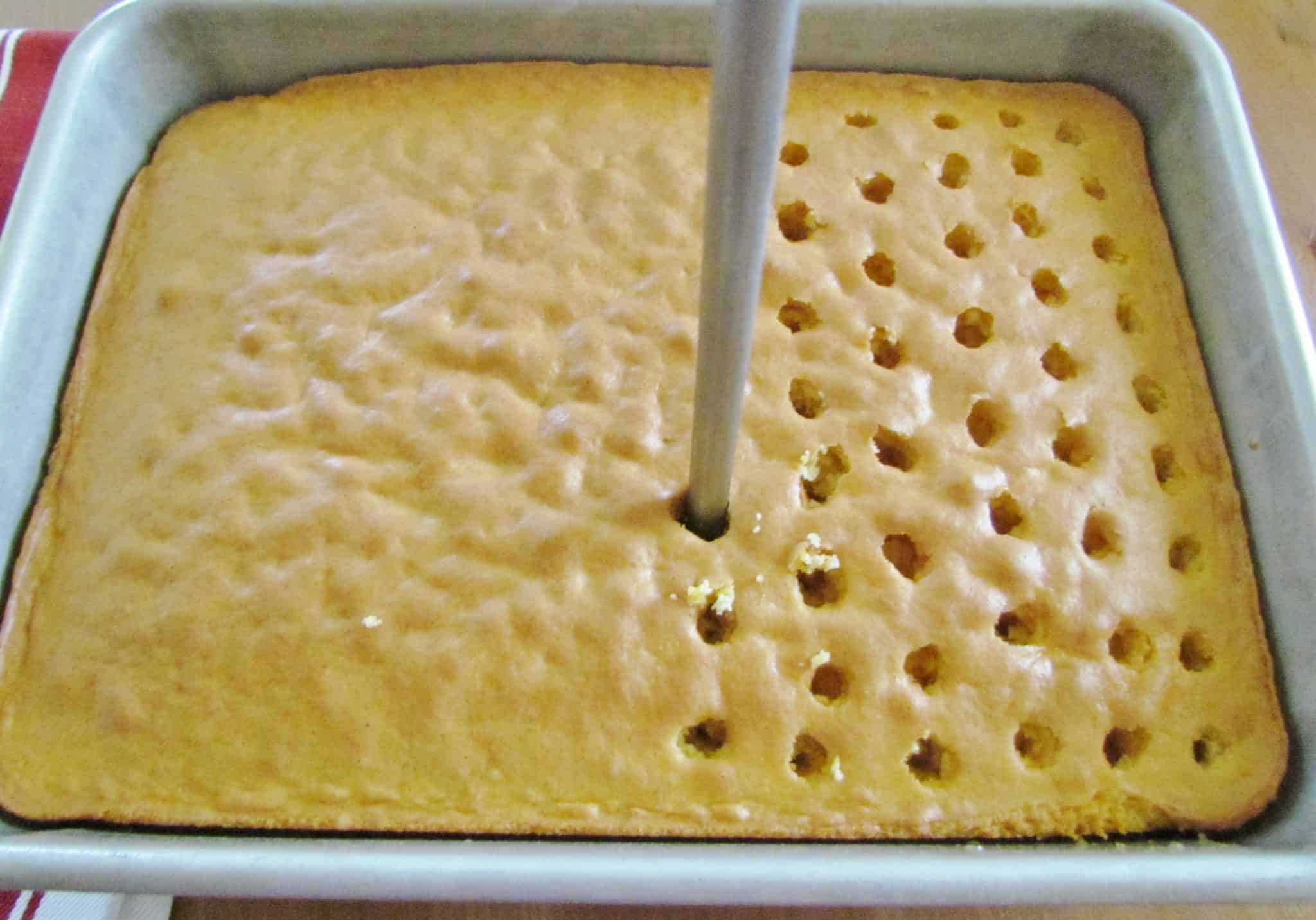 poke holes into baked yellow cake.
