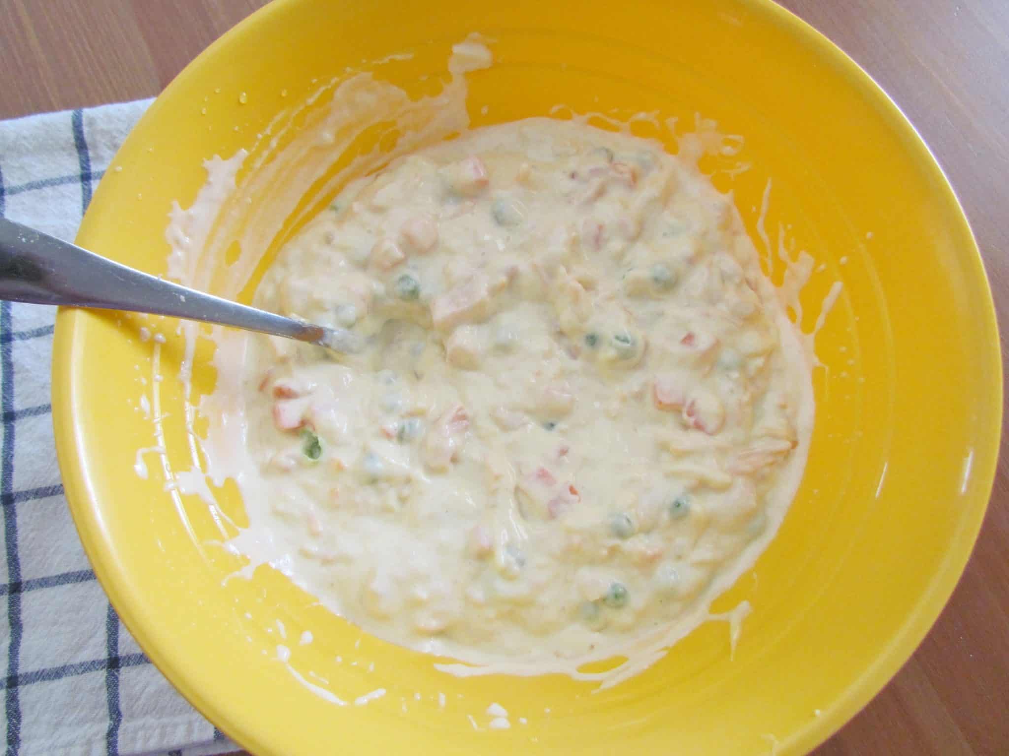 chicken, cream of chicken soup, mayonnaise, pease and carrots all mixed together in a bowl.