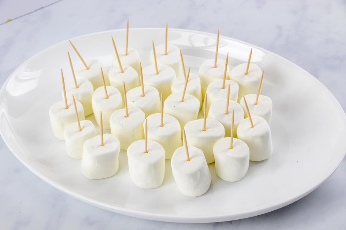 toothpicks in jumbo marshmallows on a plate.