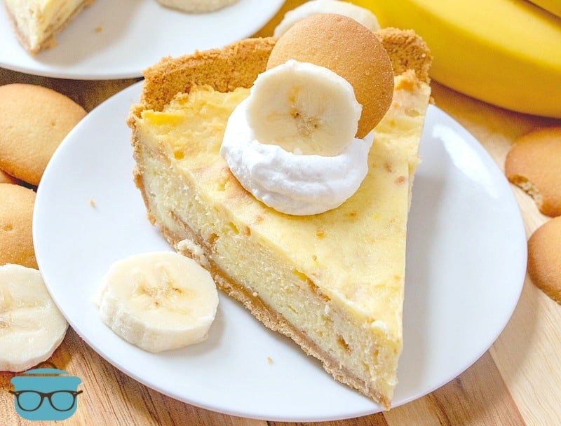 slice, Easy Banana Pudding Cheesecake on a plate with sliced bananas and whipped cream