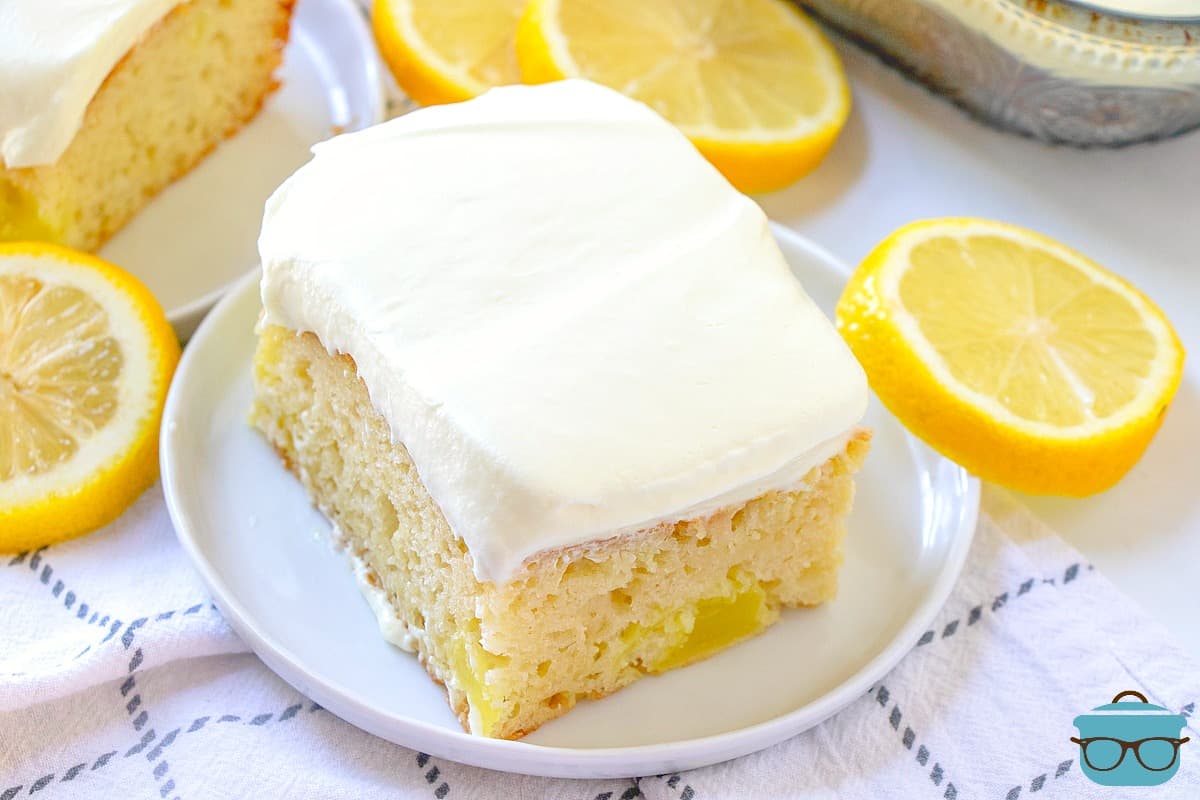 Lemon Dream Cake, slice with lemon on a white round plate.