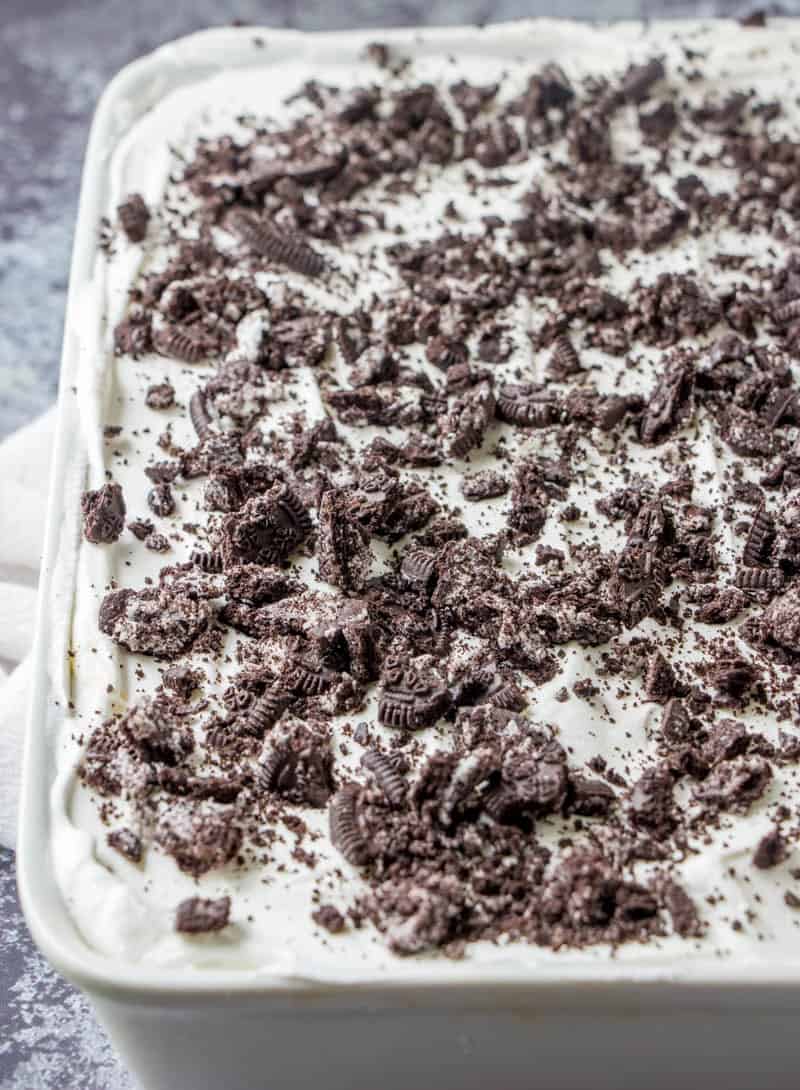whopped topping on red velvet cake topped with crushed Oreos.