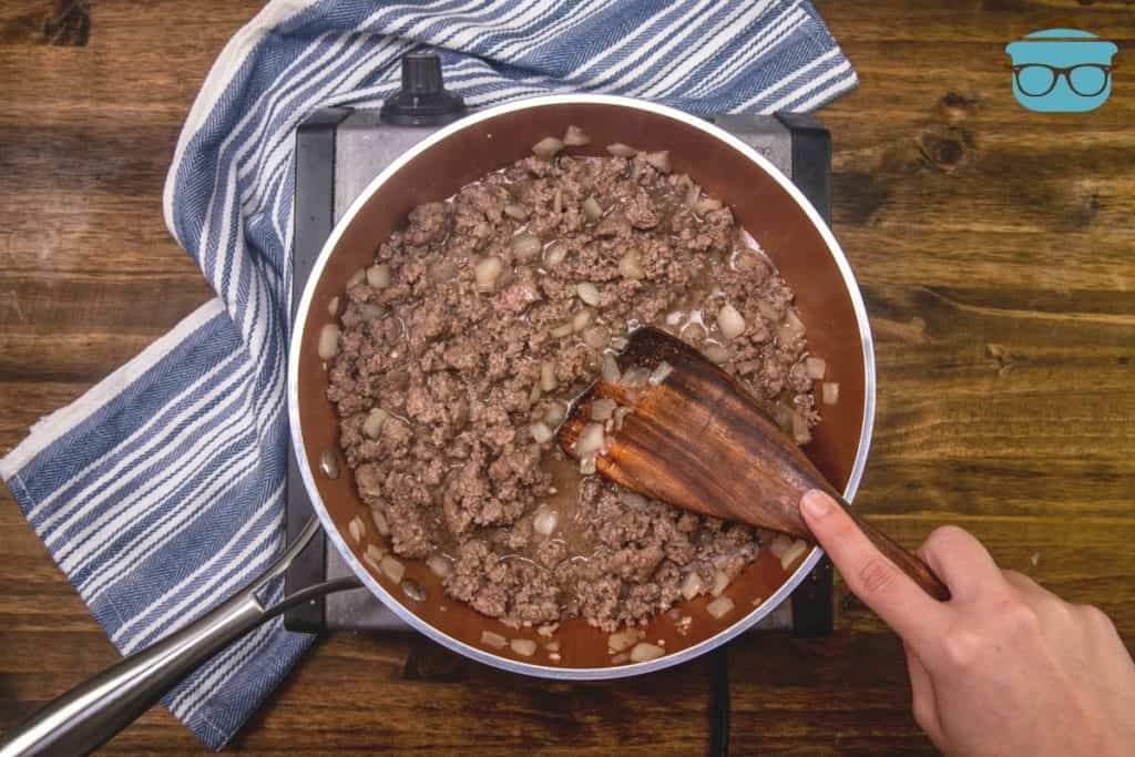 browning and crumbling ground beef with onions and garlic in a saute pan.