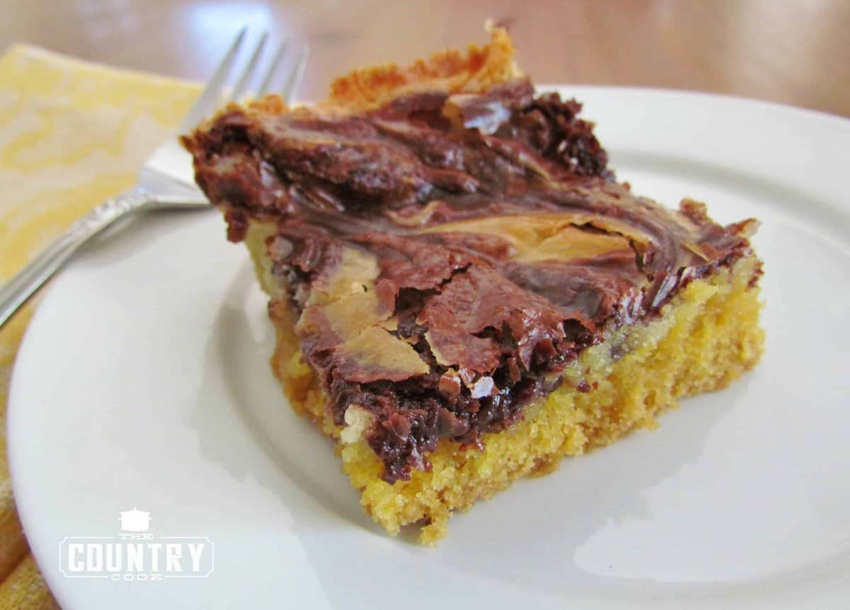 a slice of Chocolate Marble Gooey Butter Cake shown on a small, round white plate.