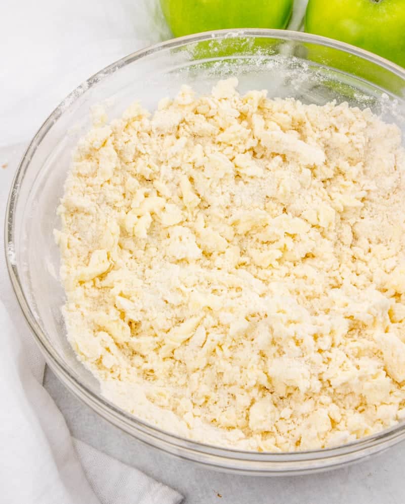 butter, flour and sugar combined in a clear bowl to make a crumble topping. 