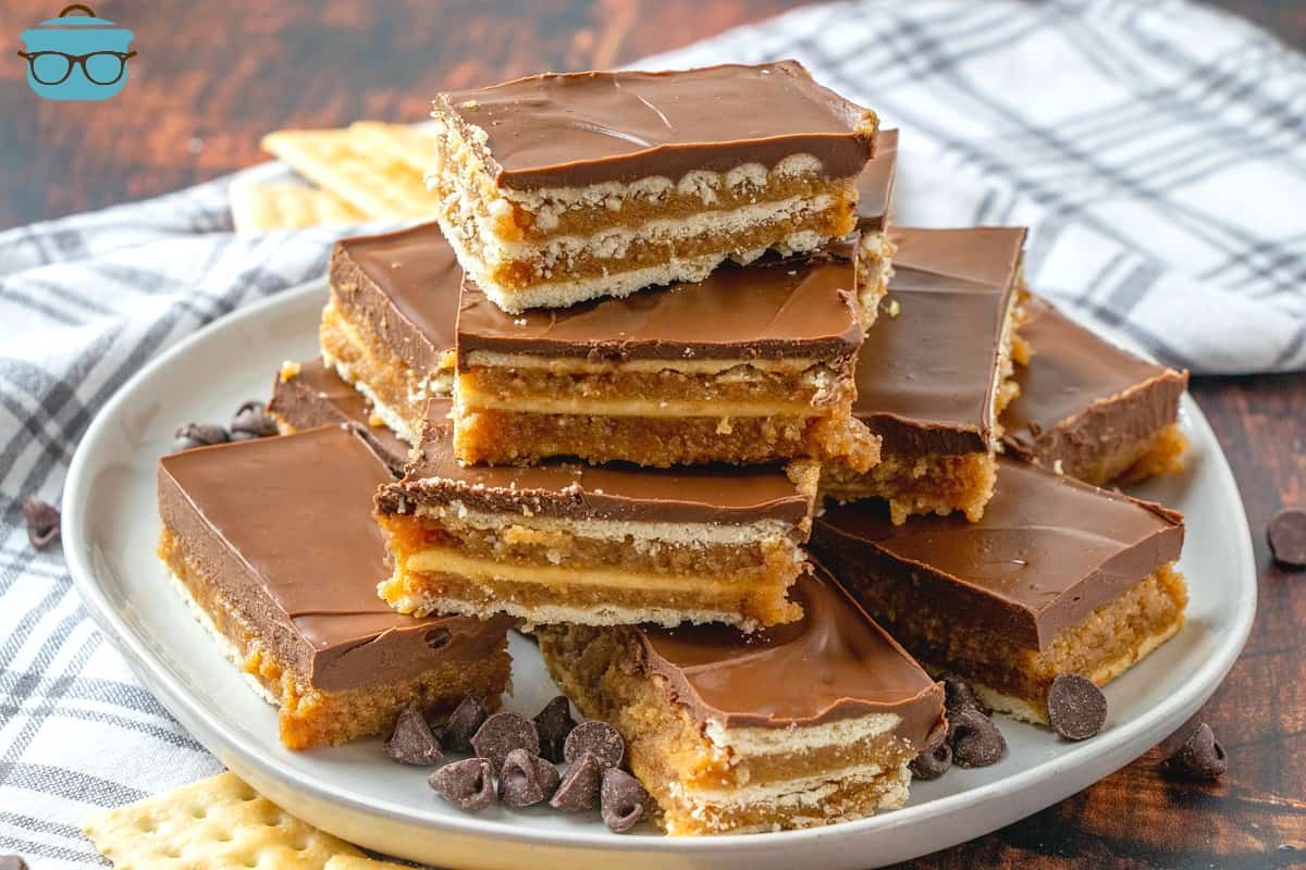 Homemade Kit Kat Bars, sliced and layered on top of a plate with crackers and chocolate chips scattered around.
