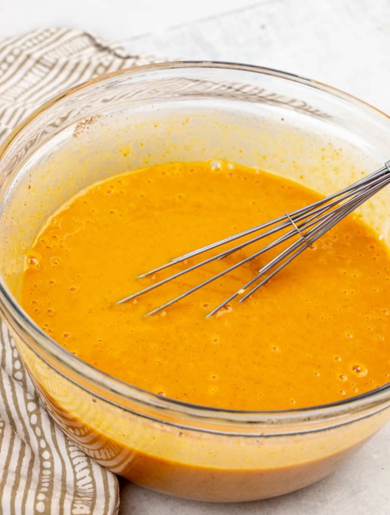 pumpkin puree, evaporated milk, eggs, sugar and cinnamon whisked together in a bowl.