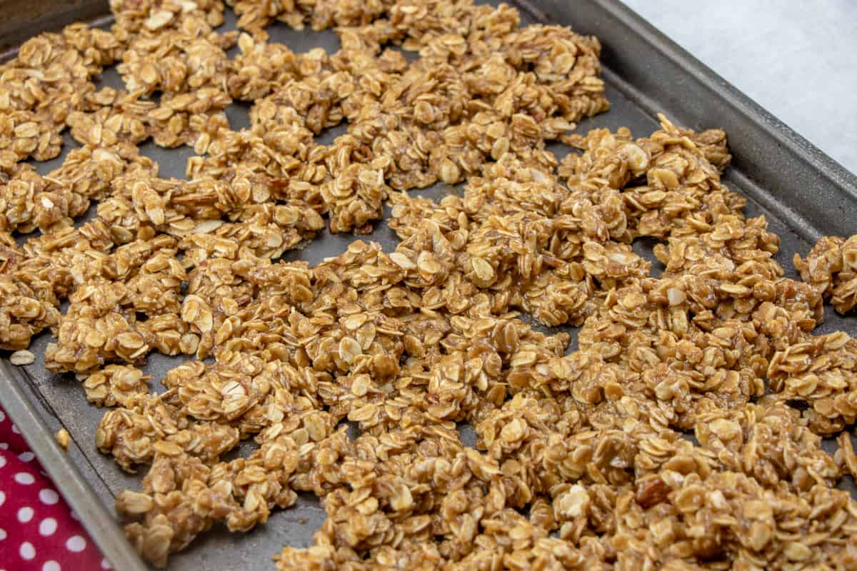 granola spread out on a baking sheet. 
