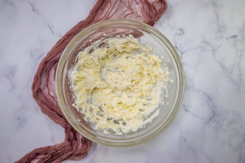butter and cream cheese mixed with an electric mixer until smooth in a clear bowl