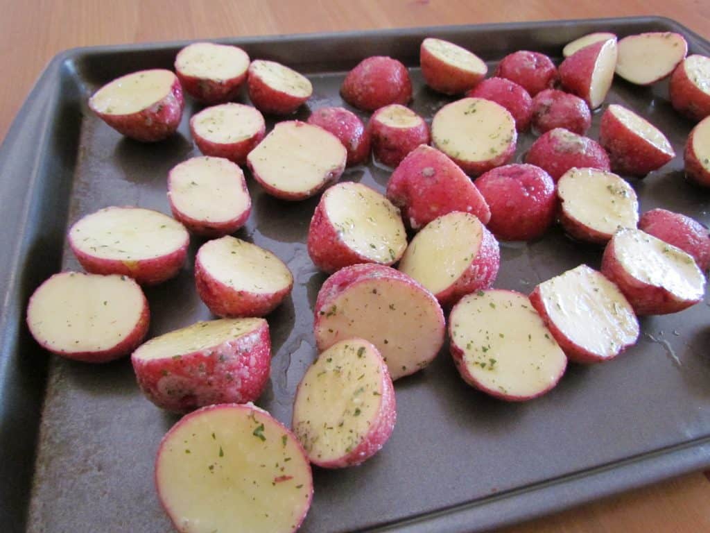 seasoned sliced potatoes on a baking sheet
