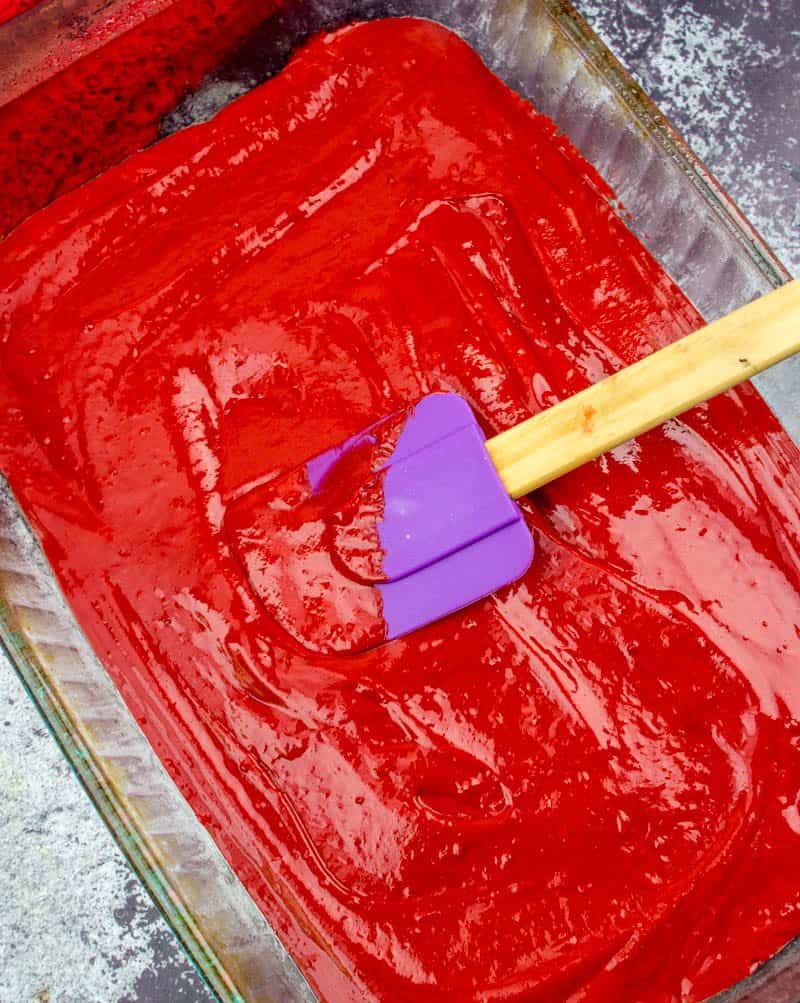 red velvet cake batter spread into a 9x13 baking dish
