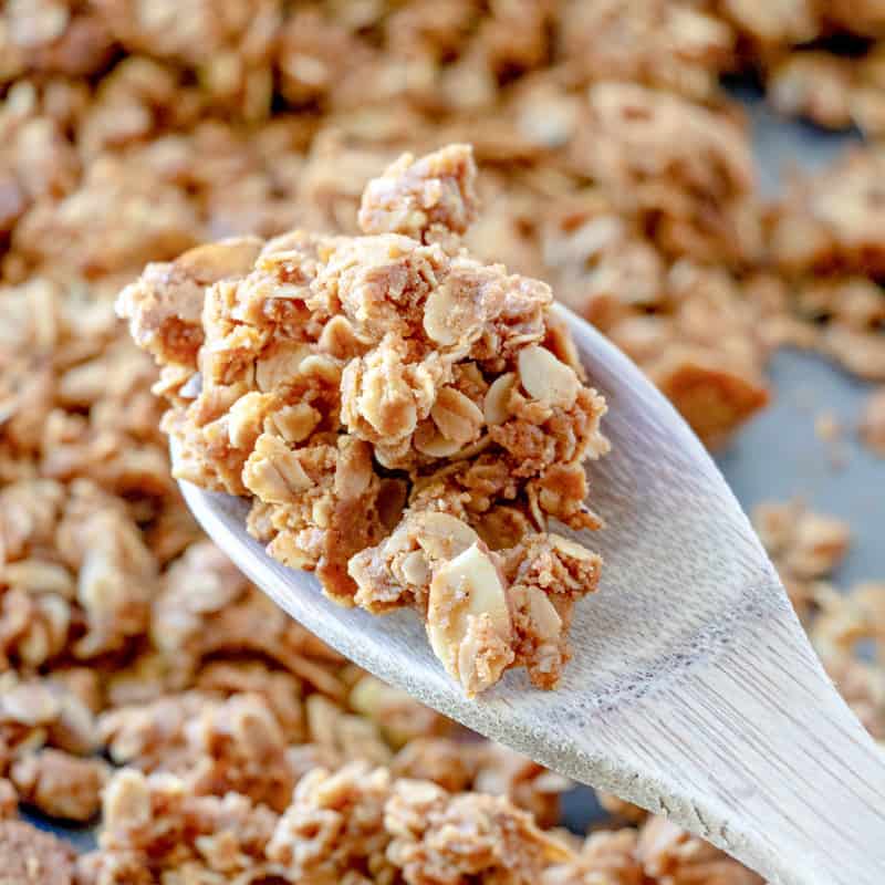 a wooden spoon holding up some homemade granola.