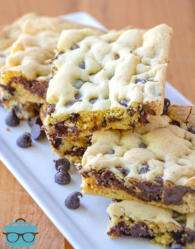 sliced, Lazy Chocolate Chip Cookie Bars on a white tray with chocolate chips.
