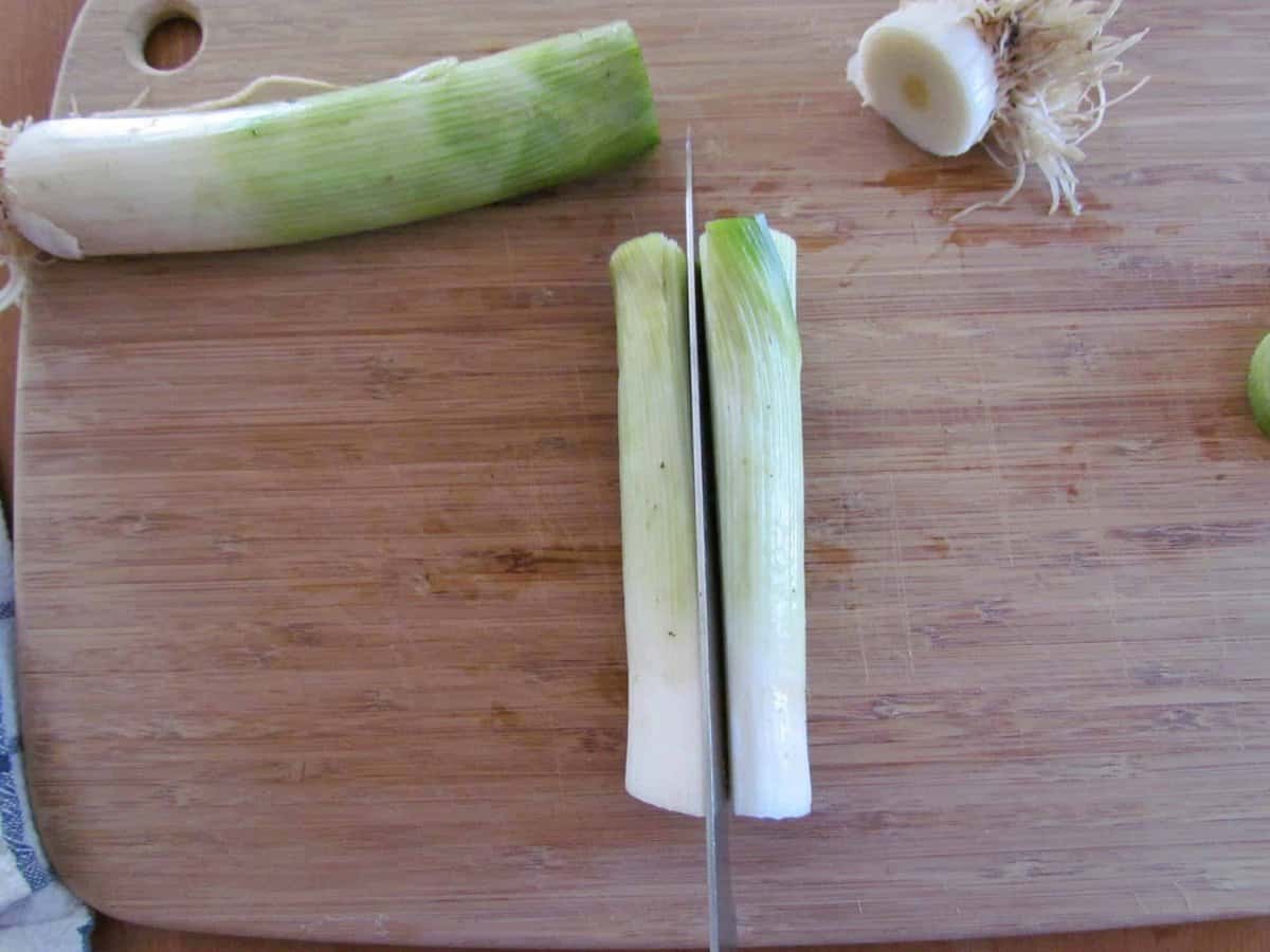 how to properly cut and handle leeks, pictured cutting a beef in half with a knife.