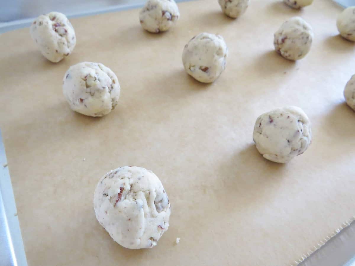 closeup photo of cookie shortbread balls on parchment paper.