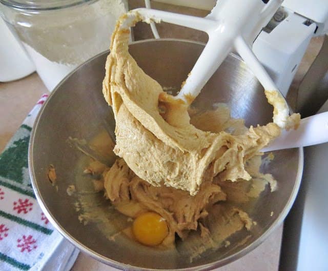eggs added to peanut butter cookie dough mixture in a mixing bowl 
