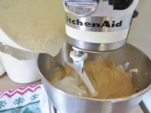 flour being added to peanut butter mixture in a stand mixer. 