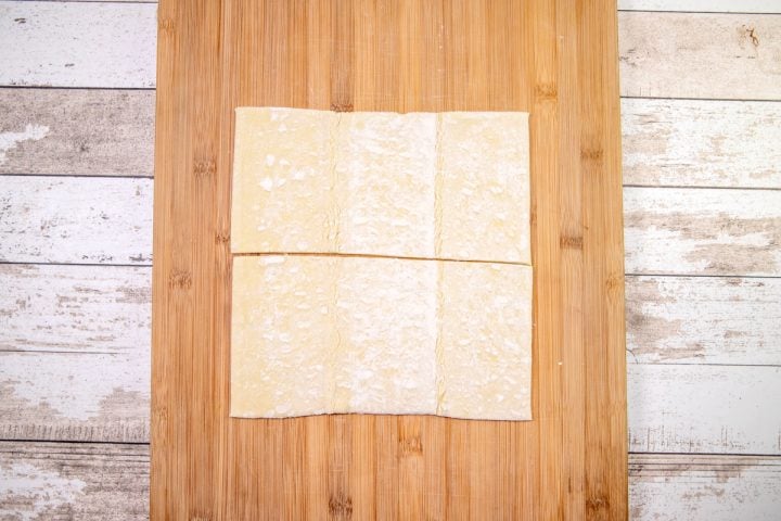 puff pastry shown cut in half and on a cutting board.