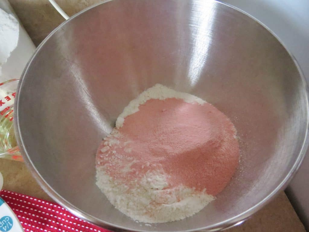 cake mix and strawberry gelatin in the bottom of an electric mixing bowl