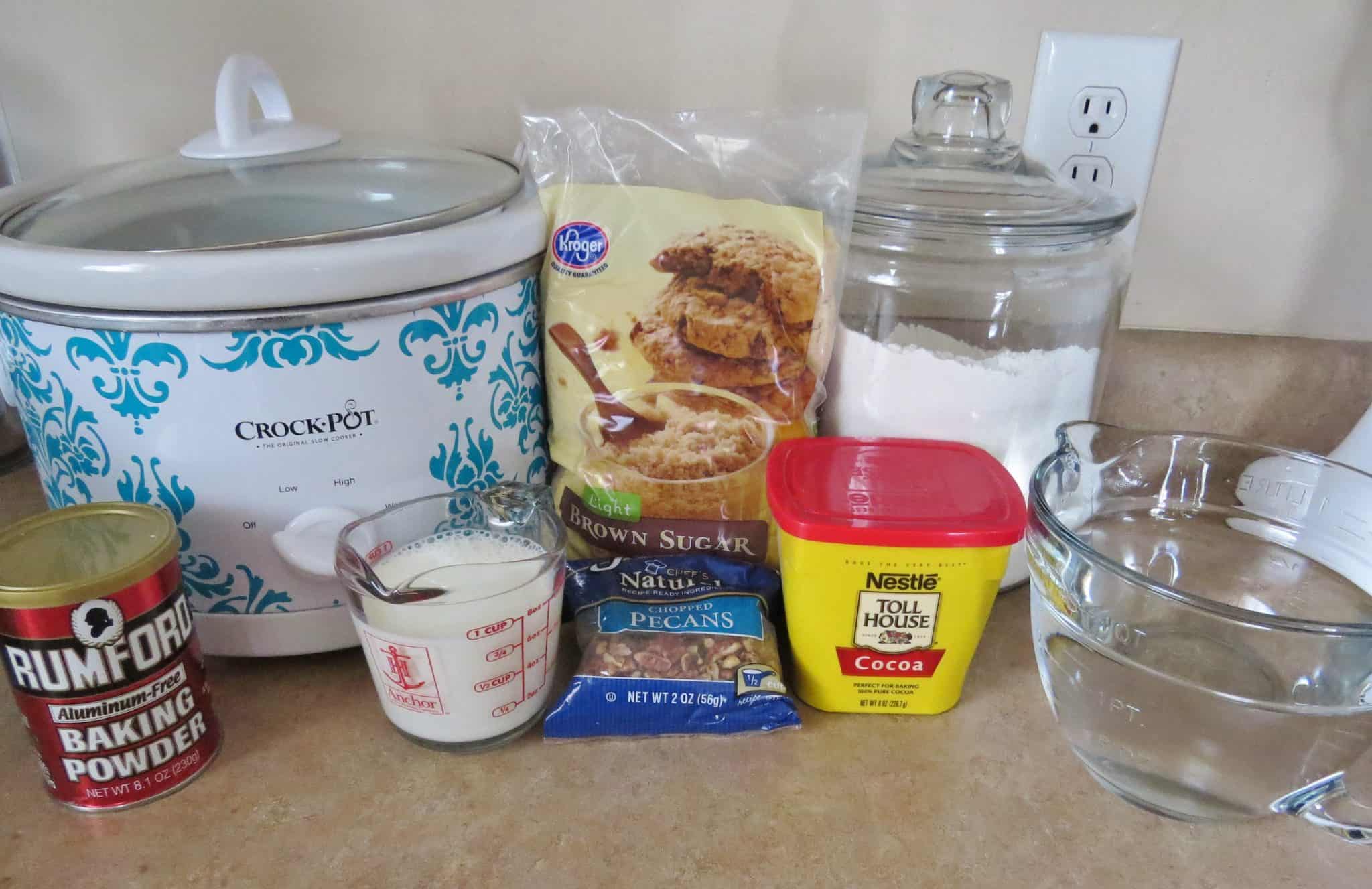 all purpose flour, sugar, cocoa powder, milk, water, baking powder and a white crock pot.