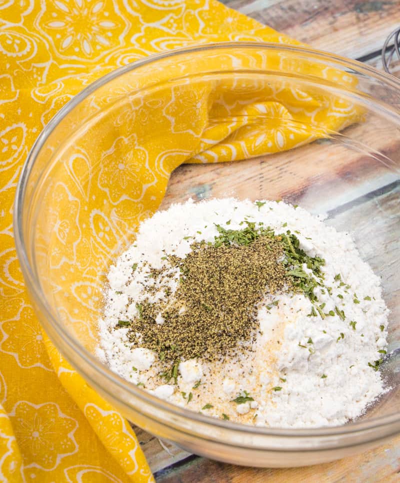 flour, baking powder, garlic powder, parsley, salt and pepper mixed in a bowl