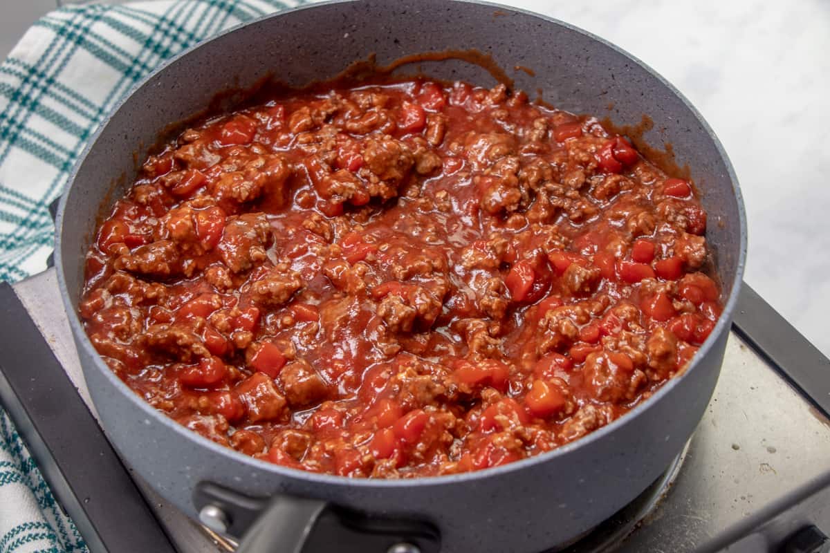 diced tomatoes, barbecue sauce, Worcestershire sauce and sugar added to cooked ground beef added to the skillet, stirred together.