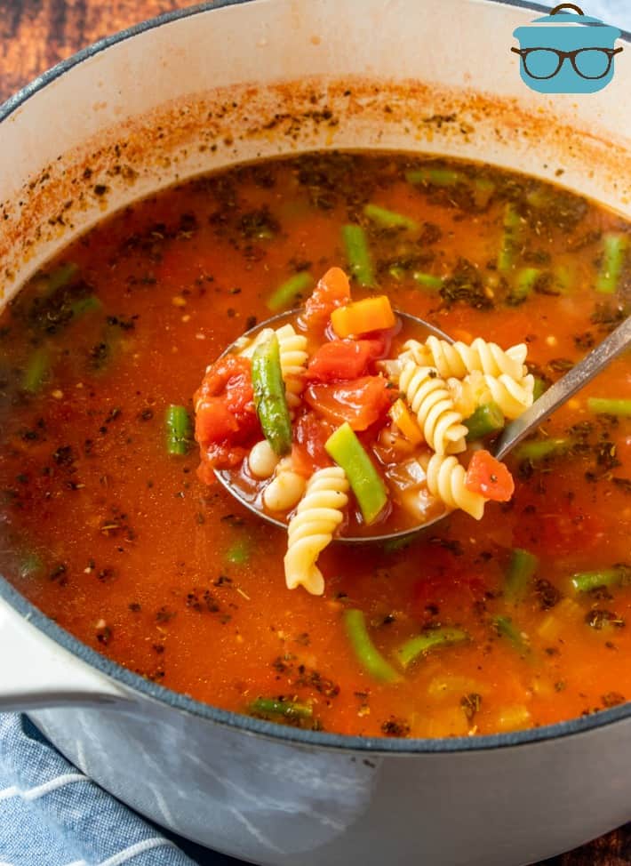 finished Minestrone Soup in a stock pot being served on a ladle