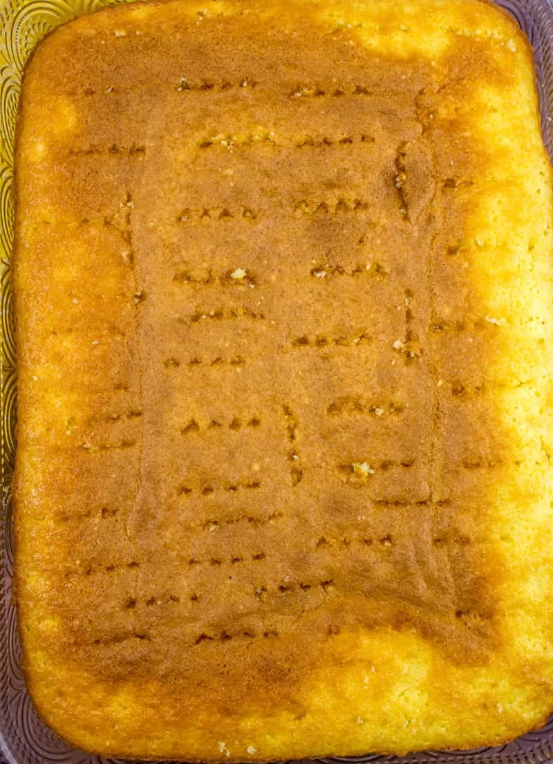 butter cake mix baked in a 9x13 baking dish with holes poked in it.