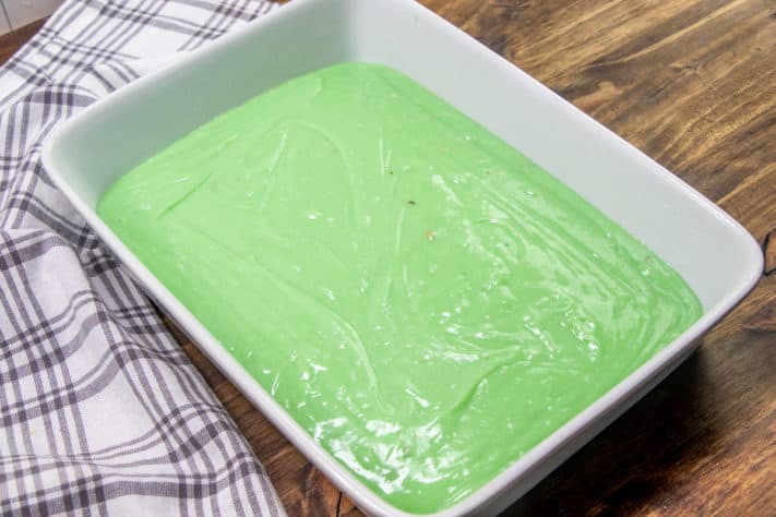 green pistachio cake batter poured into prepared baking dish