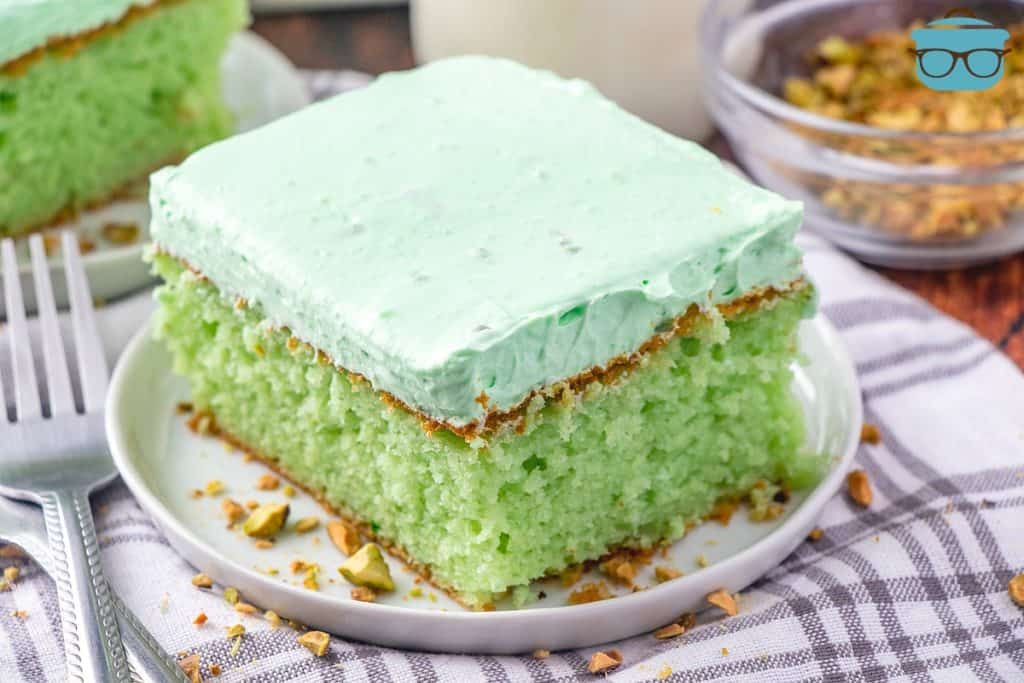 slice, easy green pistachio cake on a white plate.