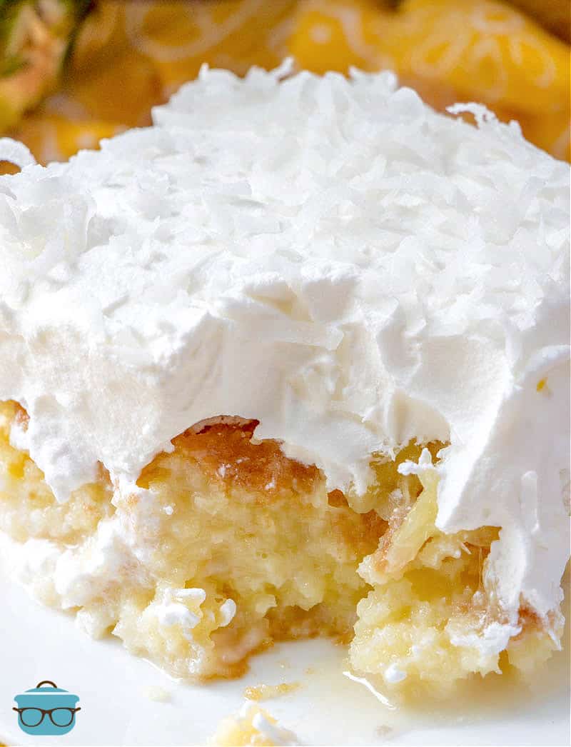 close up side photo of a slice of pina colada cake with a bite removed. 