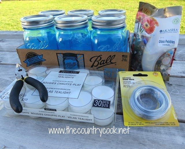 blue mason jars, 22 gauge wire, tea lights, decorative glass pebbles and needle nose pliers 