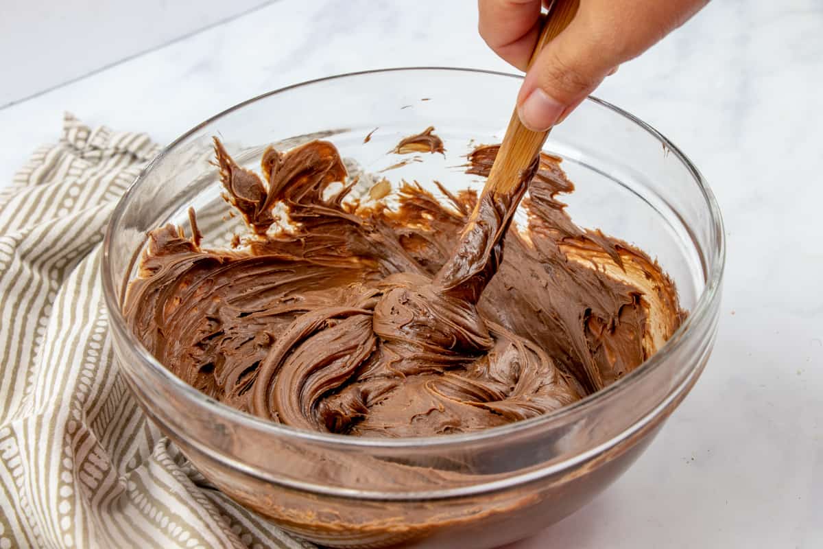 store-bought chocolate frosting stirred together with peanut butter in a glass bowl.