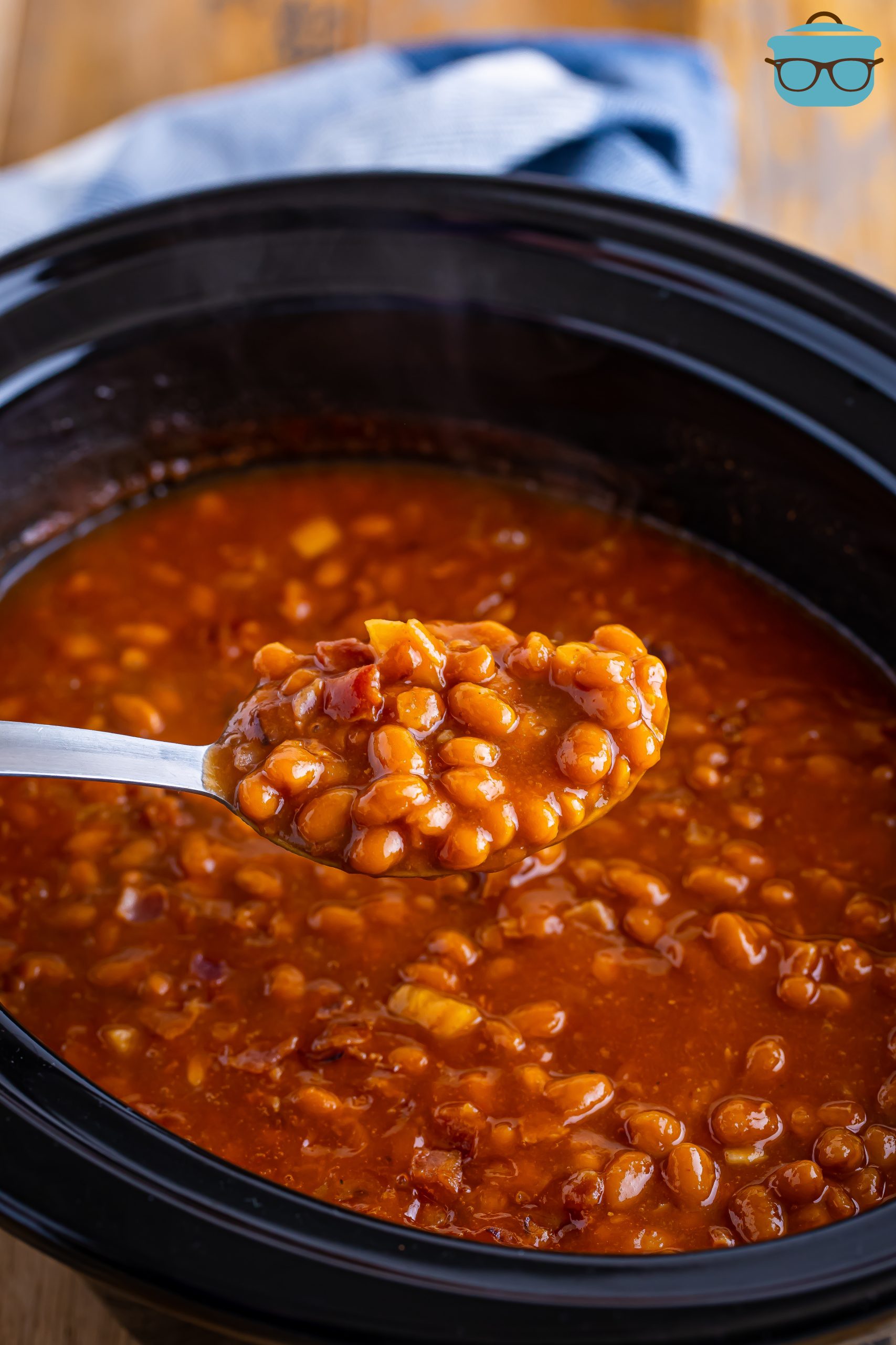 A spoon getting a scoop of Crock Pot Baked Beans.