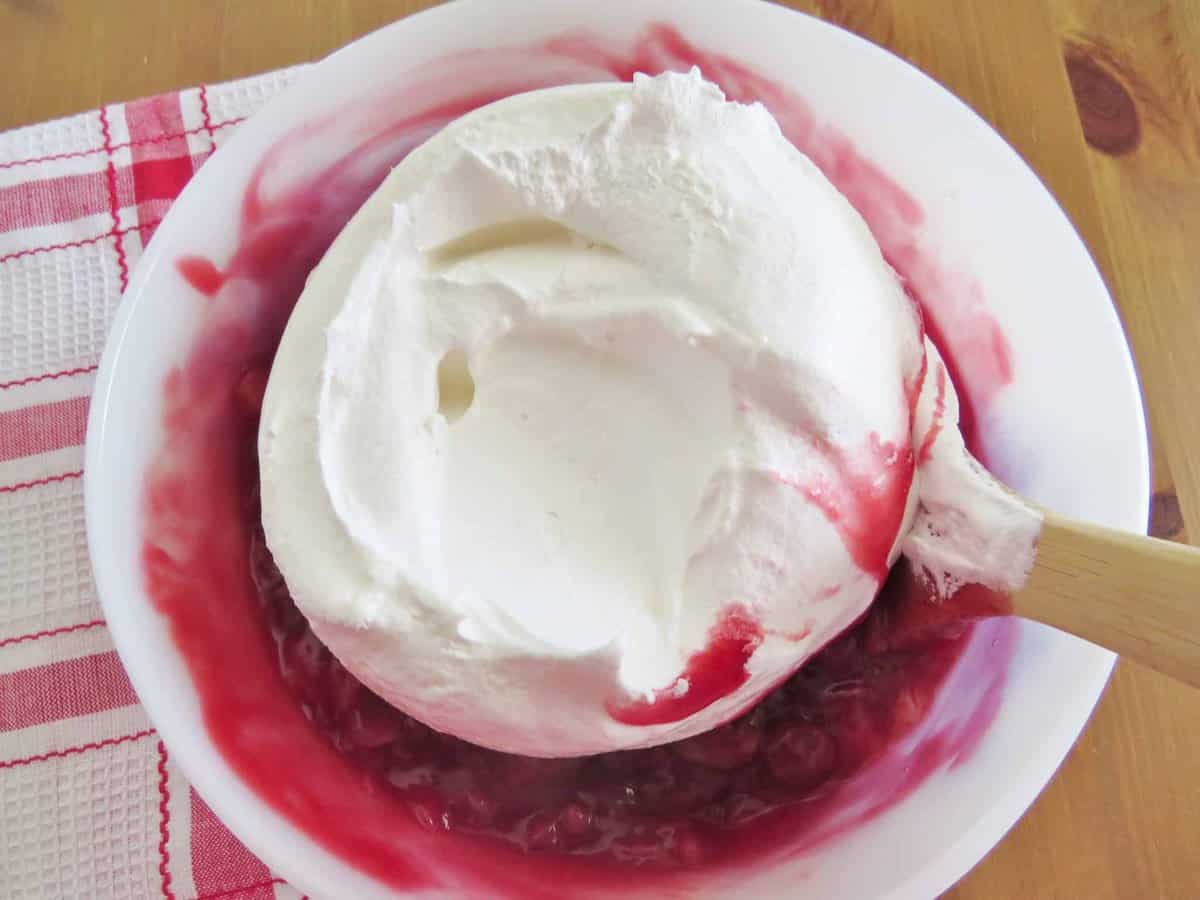 adding whipped topping to mixture.