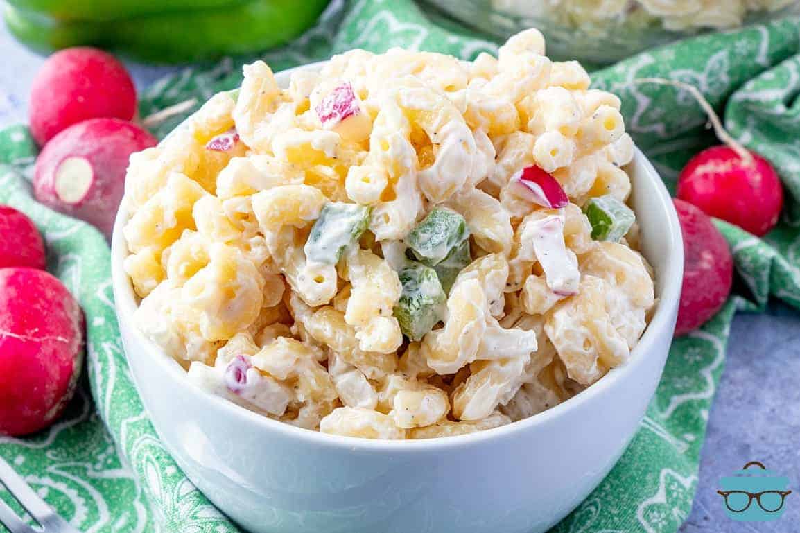 Mom's Macaroni Salad served in a white bowl with radishes shown on the side of the bowl.