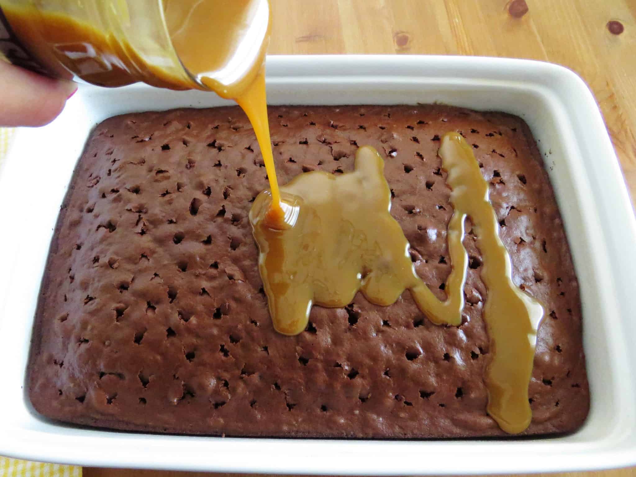 pouring jarred caramel sauce over warm chocolate cake.