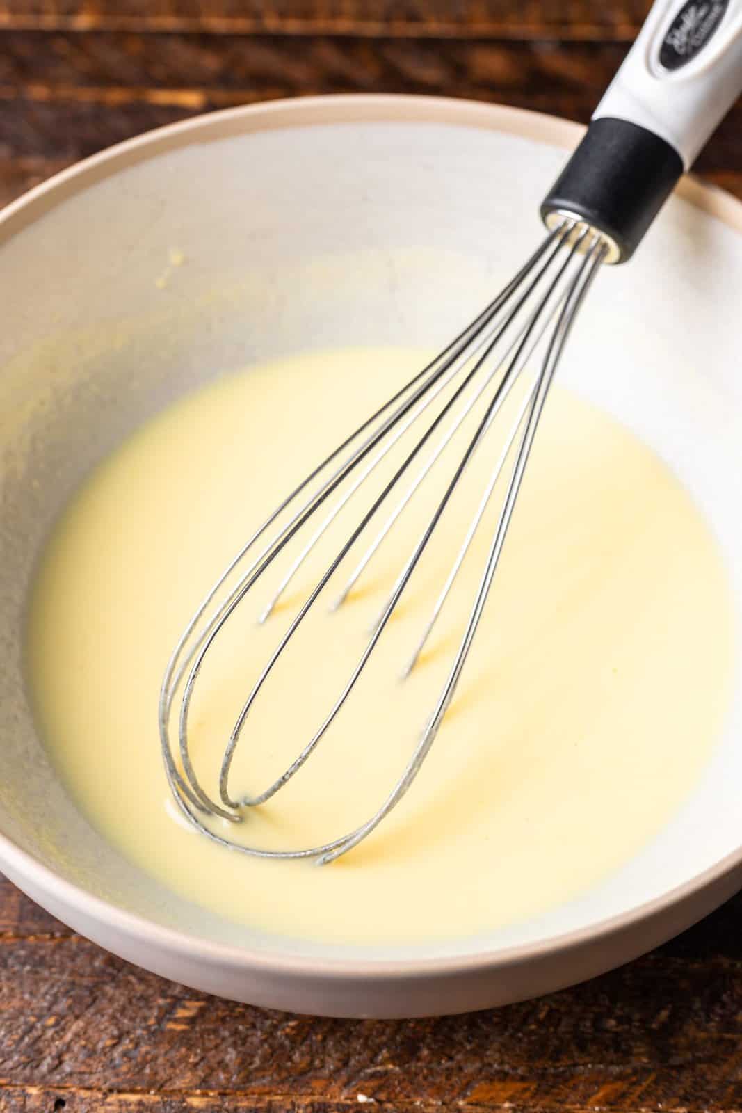 banana pudding whisked together in a bowl with milk.