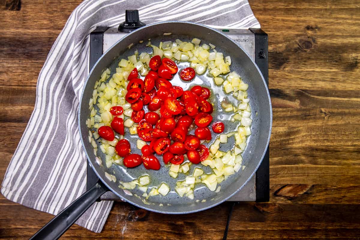 minced garlic and slice grape tomatoes added to skillet with cooked onions and olive oil.