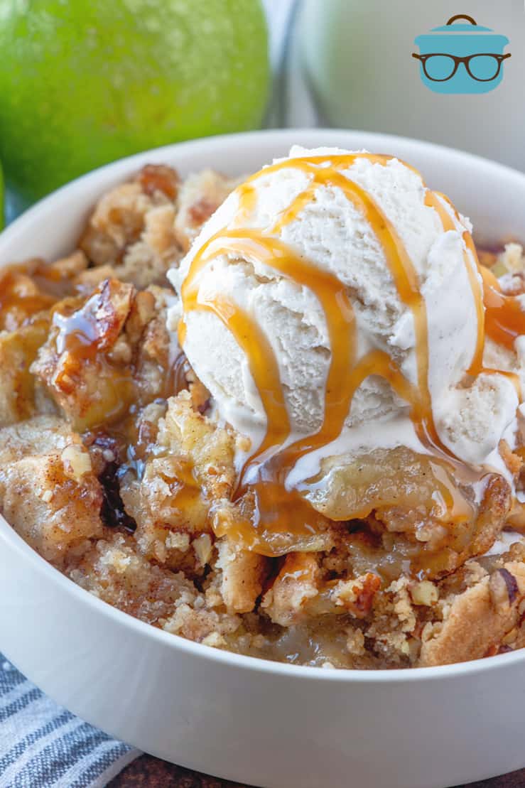 Apple Cinnamon Muffin Mix Apple Cobbler shown pictured in a white bowl, topped with a coop of vanilla ice cream and a salted caramel drizzle.