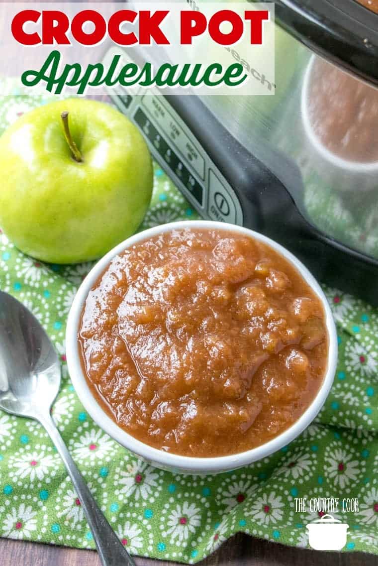 Easy Crock Pot Applesauce recipe from The Country Cook. Serving shown in a small white bowl with a green apple in the background.