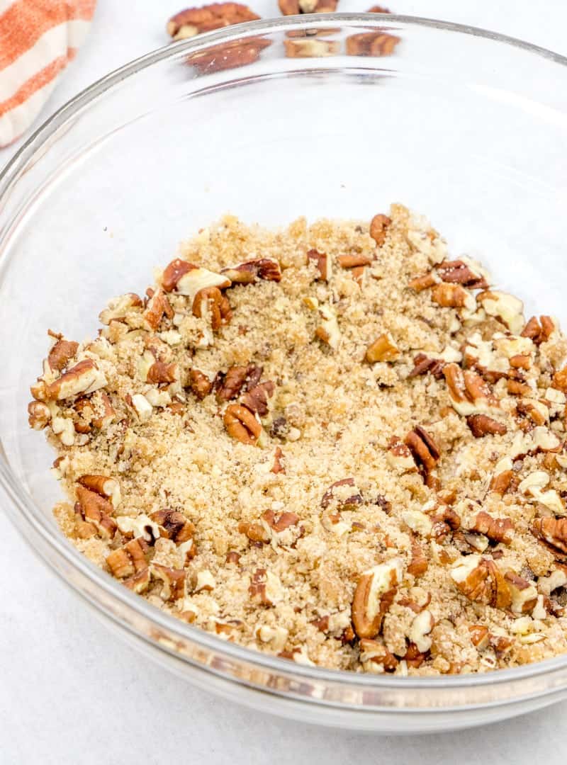 melted butter, brown sugar, chopped pecans, cinnamon, flour mixed together in a bowl.