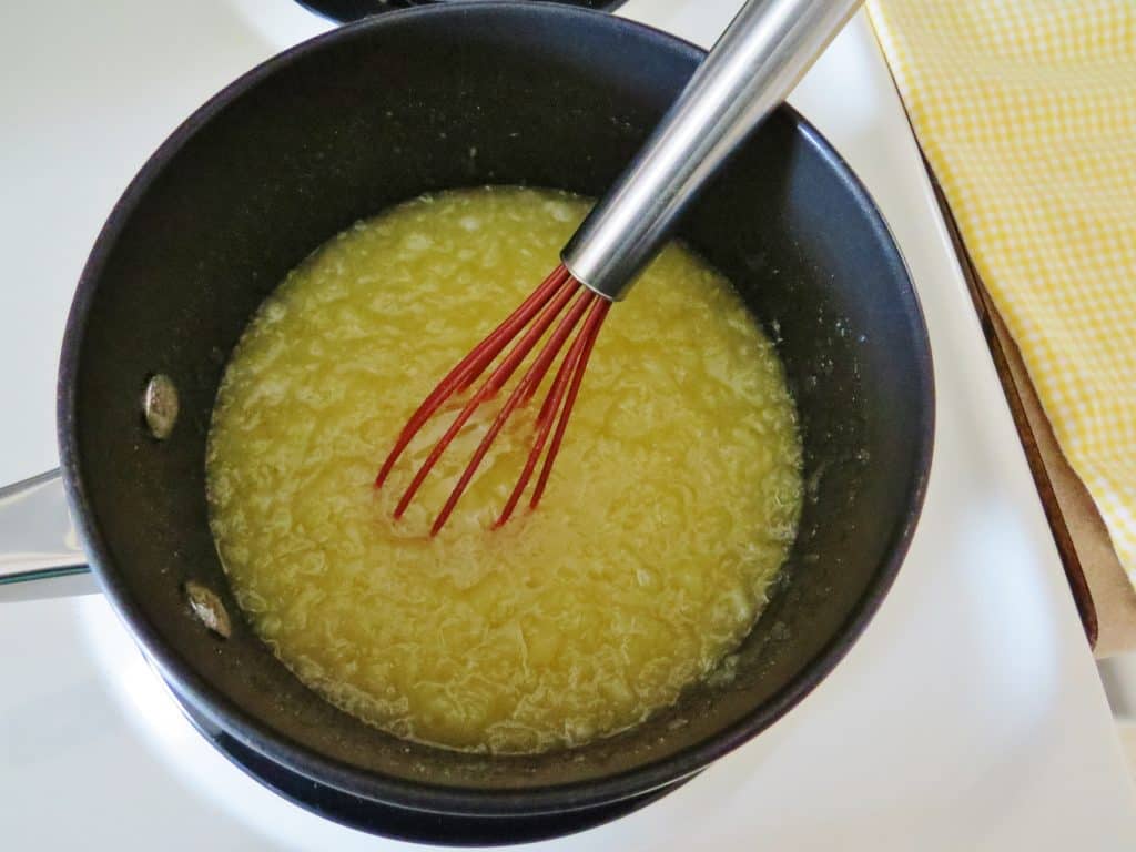 crushed pineapple and sugar in a saucepan with a whisk