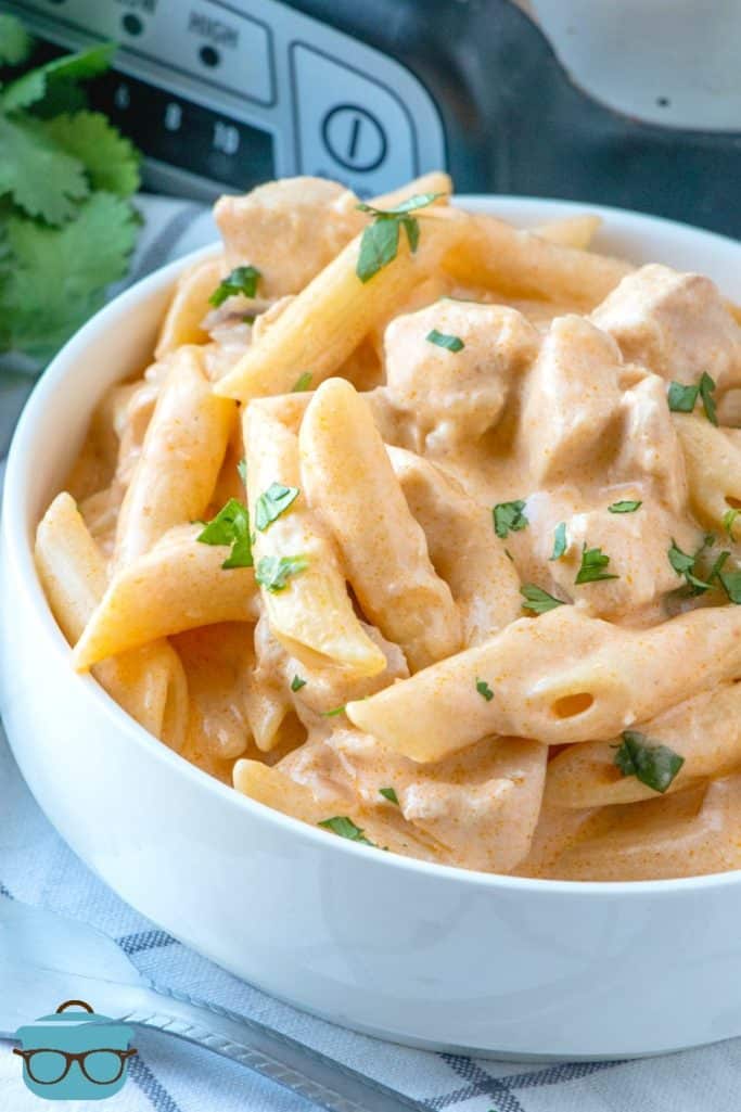Easy Crock Pot Buffalo Chicken pasta served in a white bowl and topped with chopped fresh parsley