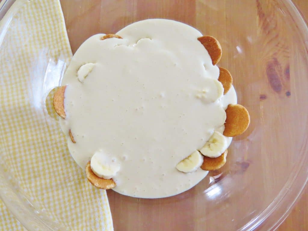 sliced bananas, Nilla Wafers added to the bottom of the bowl and topped with sweetened cream cheese mixture