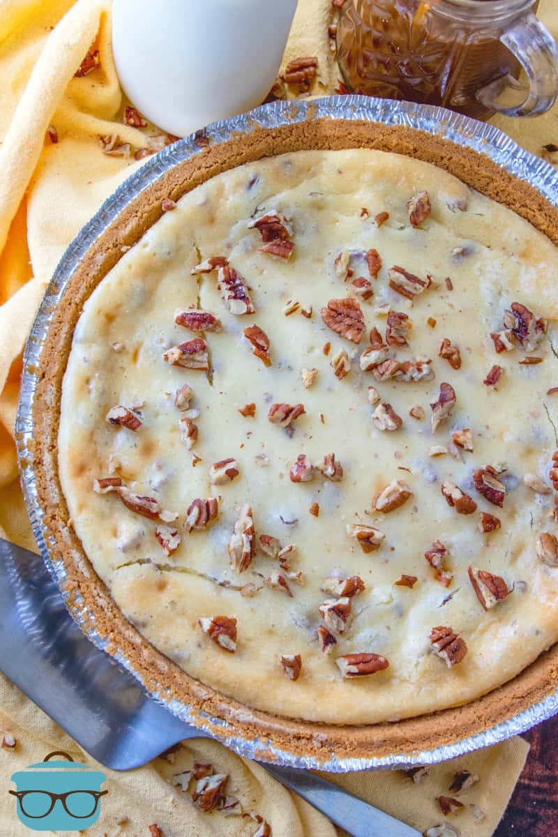 full baked and cooled, Butter Pecan Cheesecake with crushed pecans sprinkled on top.