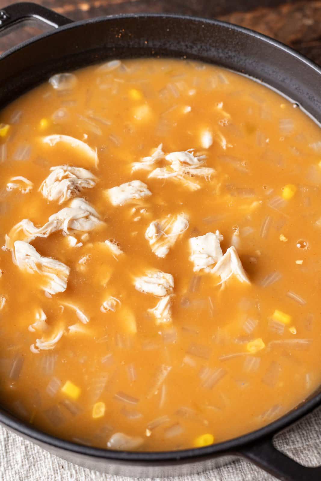taco seasoning, white beans, corn, cream of chicken soup, green chiles and chicken in a pot. 