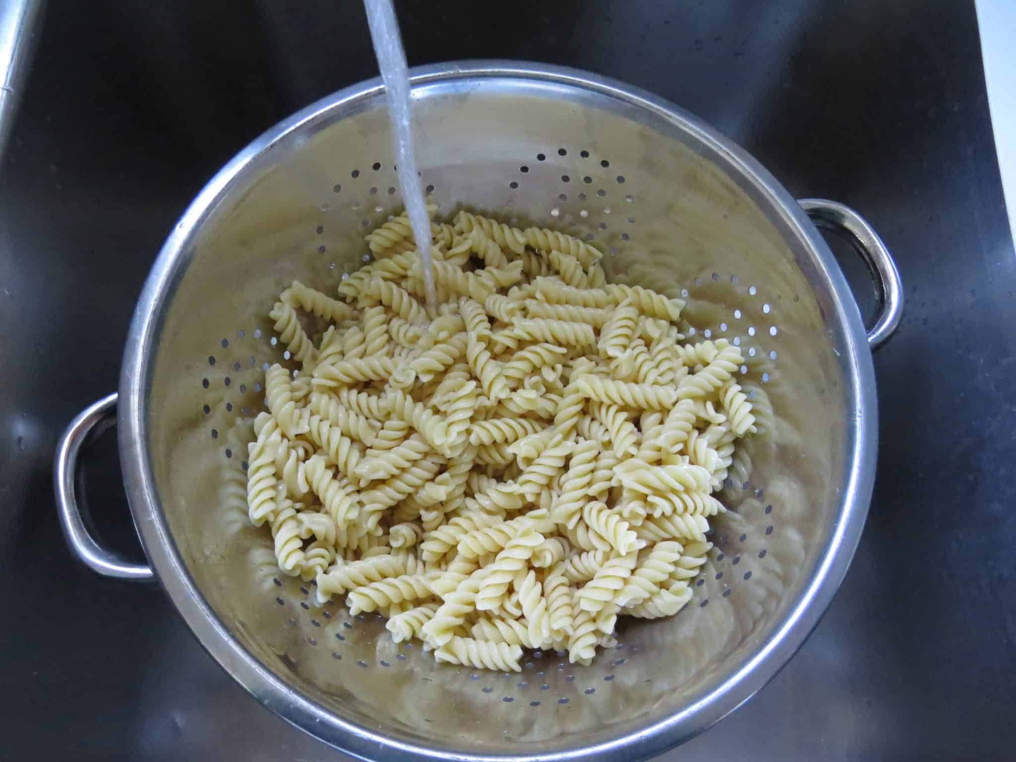 cooked rotini pasta in a colander.