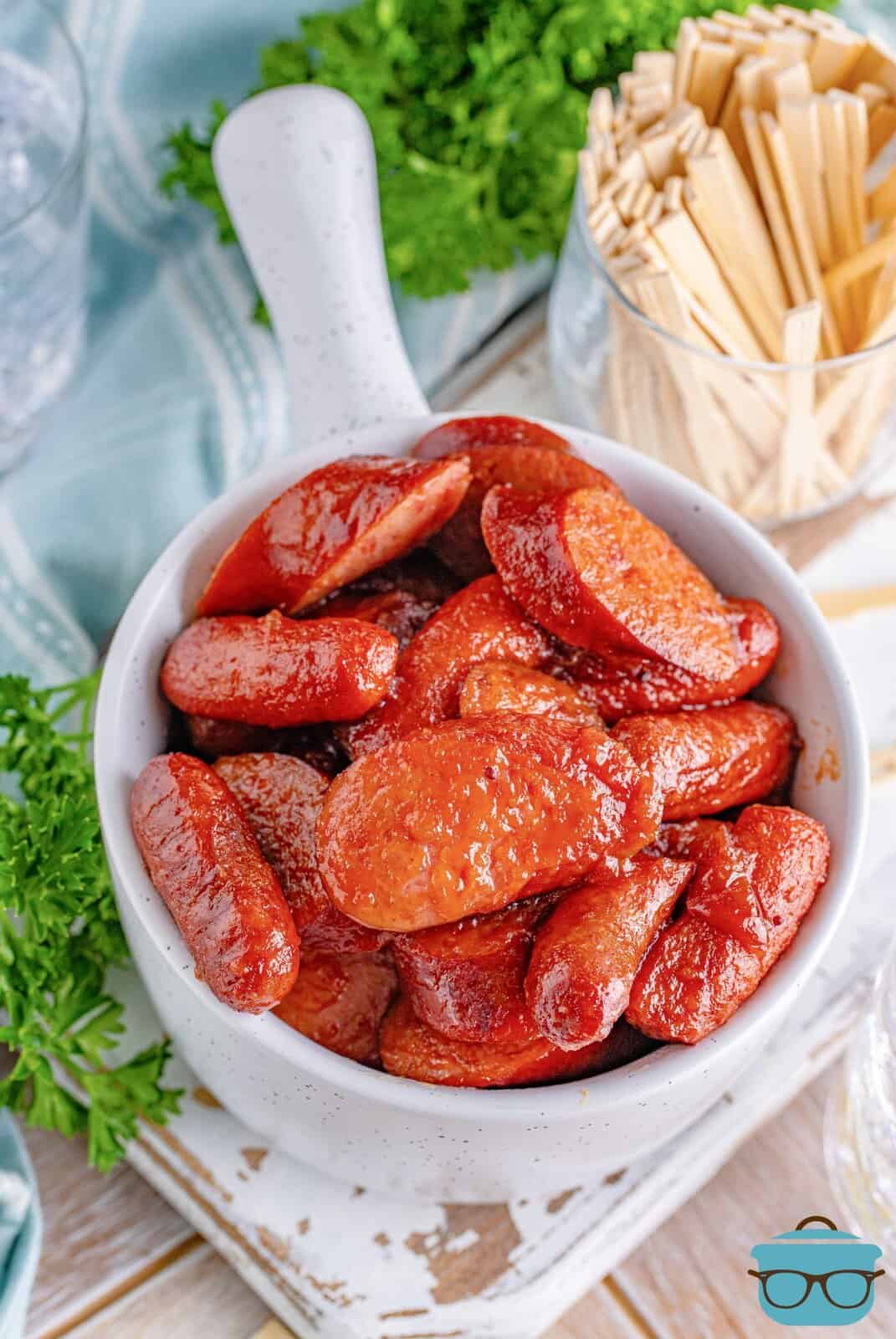 glazed sausage bites shown in a white bowl with a handle.