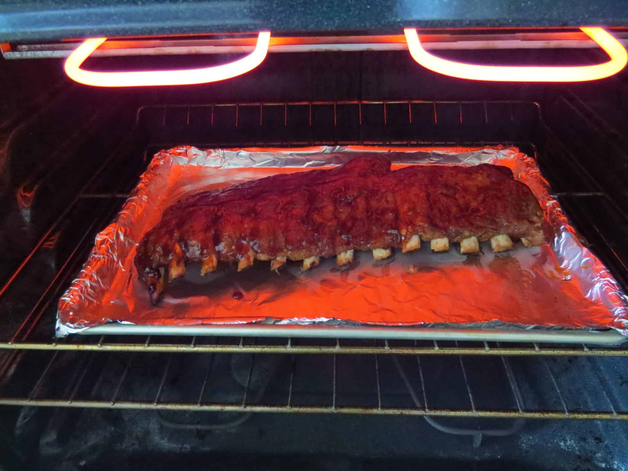 slow cooked baby back ribs on a heat pan under the oven broiler.